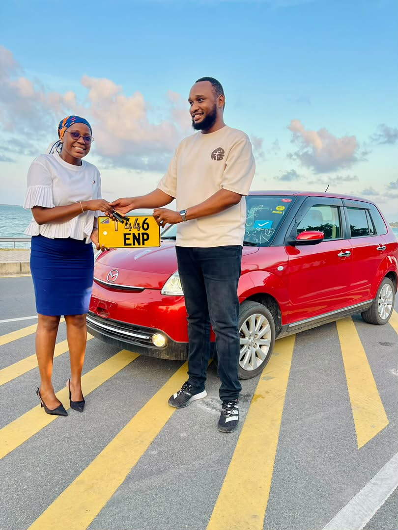 Zuri Motors customer receiving car keys for a red Mazda